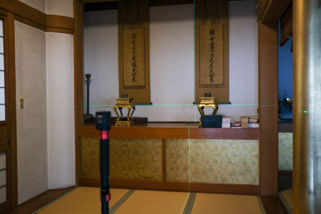 レーザー墨出し器で掛け軸の水平を確認しているところ