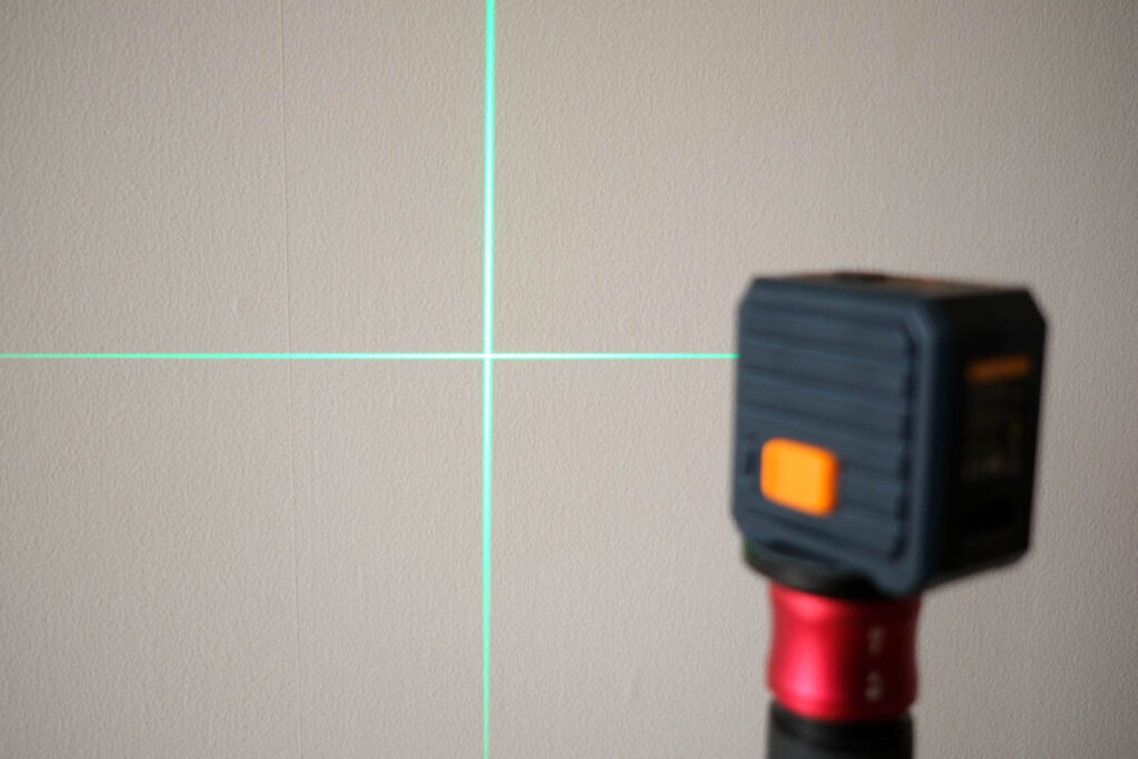 レーザー墨出し器を壁に照射して緑のレーザーを表示